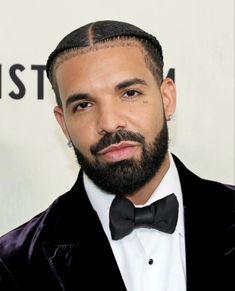 a close up of a person wearing a suit and bow tie