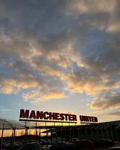 the manchester united sign is lit up at sunset