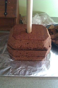 a cake with a candle sticking out of it sitting on top of tin foil next to another cake