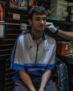 a man sitting in a chair getting his hair cut