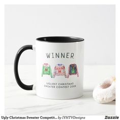 a black and white coffee mug with ugly christmas sweaters on it next to a donut