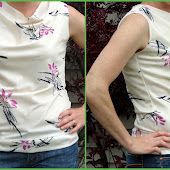 a woman with her hands on her hips wearing jeans and a t - shirt that has pink flowers on it