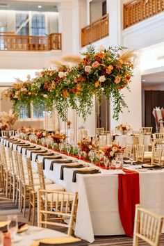 the tables are set with white linens and gold chairs