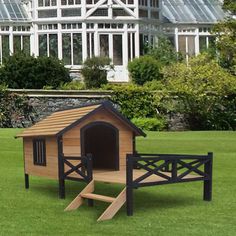 a wooden dog house with stairs in the grass