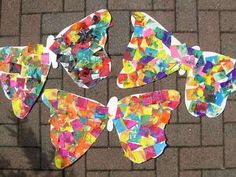 paper butterflies are arranged on the ground with colored papers cut out to look like they have been made by children