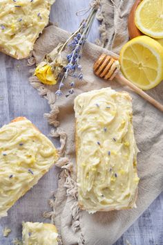 lemon cake with frosting and lavender sprinkles next to sliced lemons