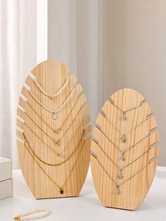 two wooden jewelry displays on a white table