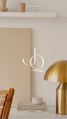 a table with a lamp and books on top of it next to a wall mounted shelf