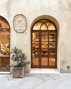 a building with two doors and a potted plant in front of the entrance to it