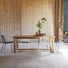 two chairs and a table in front of a wooden wall