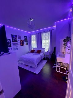 a bedroom with purple lighting and white bedding