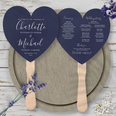 two heart shaped wooden paddles with names on them sitting next to some lavender flowers