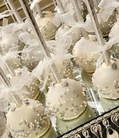 some white cake pops with bows and pearls on them