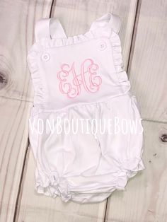 This white ruffled romper is so cute and comfy ! Perfect for summer and every day wear ! 100 % cotton, knit fabric (so soft!) Elastic in leg opening Snaps in crotch  Buttons at shoulder PERSONALIZATION CAN BE IN ANY COLOR ! (light pink shown with vine monogram - hot pink shown in Fancy monogram) Please leave the name or full name (for monogram) in the notes to seller section during checkout, along with thread color  Other designs available ! Please message me to start your custom order :) any ot Cute Bubble Romper With Ruffle Hem For Spring, Cute Spring Bubble Romper With Ruffle Hem, Cute Cotton Bubble Romper With Ruffle Hem, Sleeveless Summer Bubble Romper With Ruffles, Spring Sleeveless Onesie With Ruffles, Sleeveless Spring Onesie With Ruffles, Spring White Ruffled Onesie, White Sleeveless Ruffled Jumpsuits And Rompers, White Sleeveless Jumpsuit With Ruffles