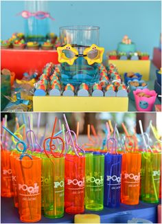 there are many colorful cups with straws in them on the table at this birthday party