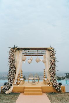 an outdoor ceremony setup with flowers and lanterns