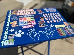 a blue table topped with lots of stickers and writing on it's sides