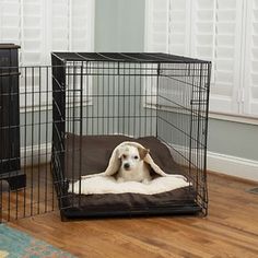 a dog laying in its cage on the floor