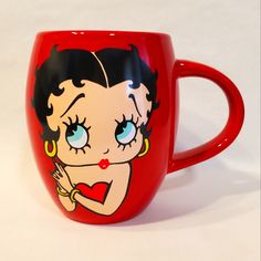 a red coffee mug with a cartoon character painted on it