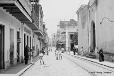 an old black and white photo of people walking down the street