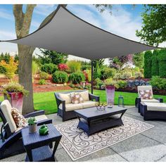 an outdoor living area with furniture and a large white shade over the couches,