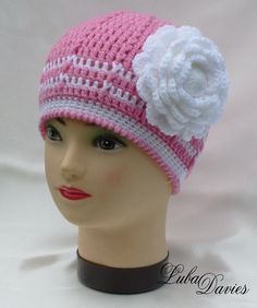 a mannequin head wearing a pink and white crocheted hat with flower