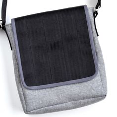 a gray and black bag sitting on top of a white table