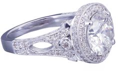 an oval cut diamond ring set in white gold with diamonds around the band and shoulders