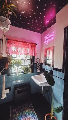 a bathroom decorated in pink and blue with stars painted on the ceiling above the sink