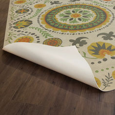 an area rug on the floor with wood floors and white paper covering it's edges