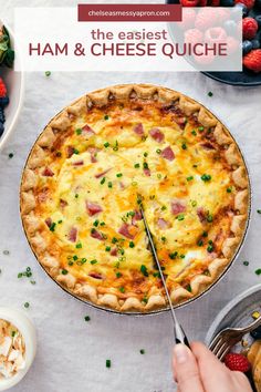 a pie with ham and cheese on it sitting next to other desserts including strawberries