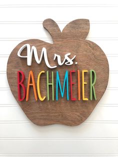 a wooden sign with the words mrs bachmier written in multicolored letters