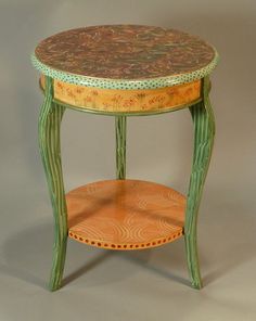 a small wooden table with an ornate design on it's top and bottom shelf