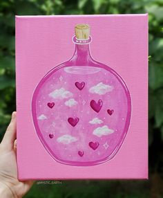 a hand holding up a pink card with hearts in a bottle on the front and bottom