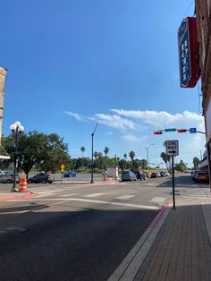 an intersection with cars parked on the side of it and traffic lights in the background