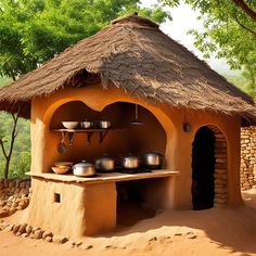 an outdoor kitchen with pots and pans on the stove, in front of a tree