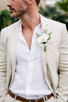 a man in a suit with a boutonniere and white flowers on his lapel