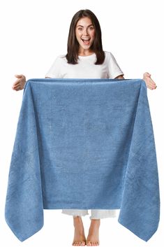 a woman is holding up a blue towel