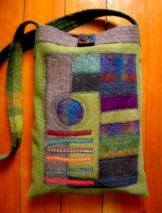 a green bag with multicolored squares and circles on the front is sitting on a wooden floor