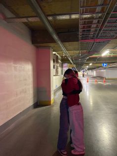 two people hugging in an empty parking garage