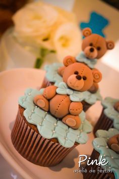 two cupcakes with teddy bears on them sitting on top of a white plate