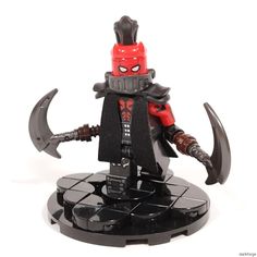 a lego figurine is shown with two axes and a red mask on it