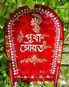 a red and white sign hanging from the side of a wooden fence in front of green leaves