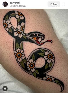 a snake with flowers on it's legs and the number six tattoo design is shown