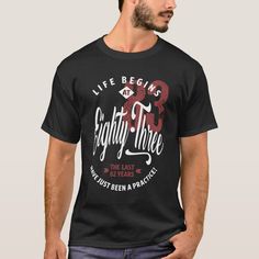 a man wearing a black t - shirt that says, life begins eighty three the last twenty