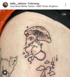 a woman's thigh with an image of a cat, mouse and umbrella on it