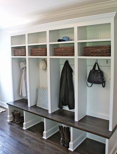 a coat rack filled with coats and purses on top of a hard wood floor