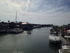 boats are docked in the water near some houses and piers on a sunny day