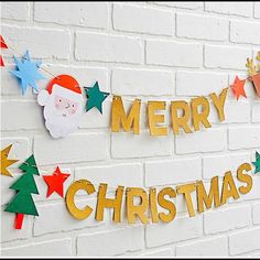 merry christmas decorations on a brick wall with santa clause and stars hanging from the side