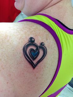 a woman with a heart and crown tattoo on her shoulder